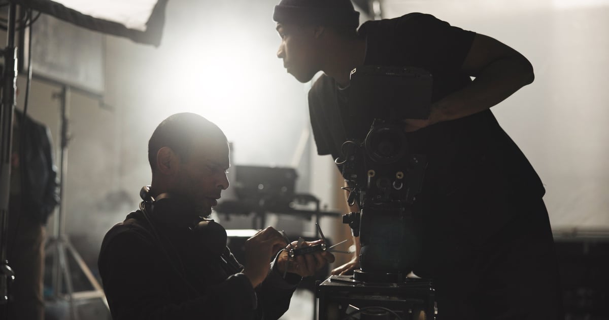Film producer and director in conversation with crew on set in studio