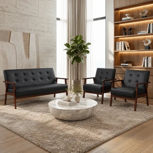 Modern living room with black leather sofa and armchairs, round stone table, beige rug, wooden shelving, and decorative plant arrangement