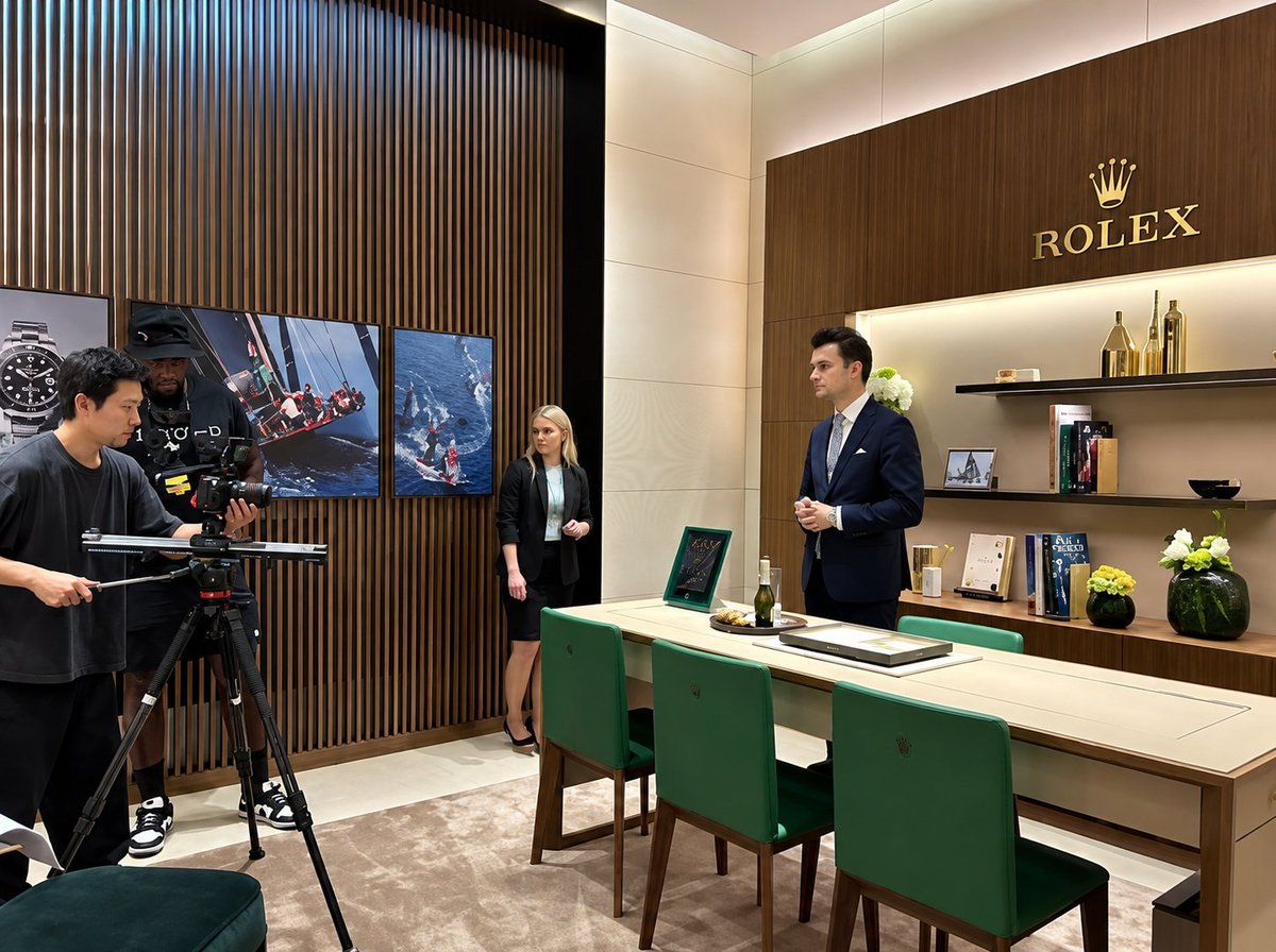 Rolex luxury watch boutique interior with production crew and display shelves