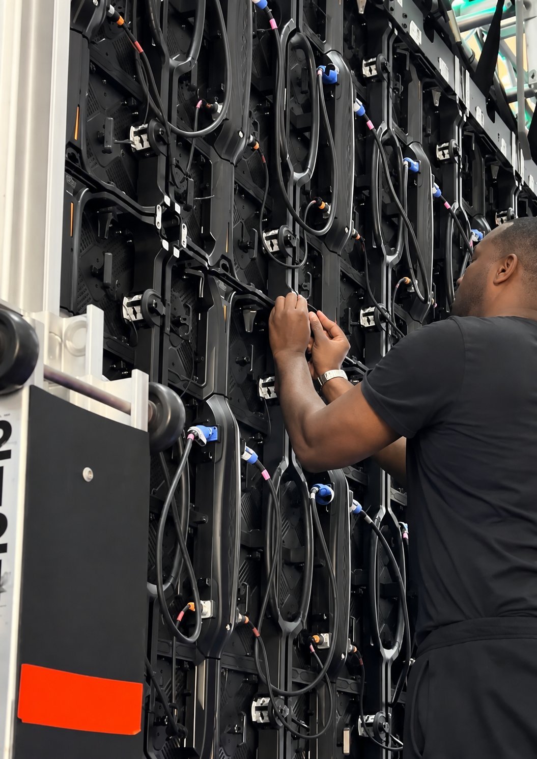 Technician working on a large LED video wall during live event build